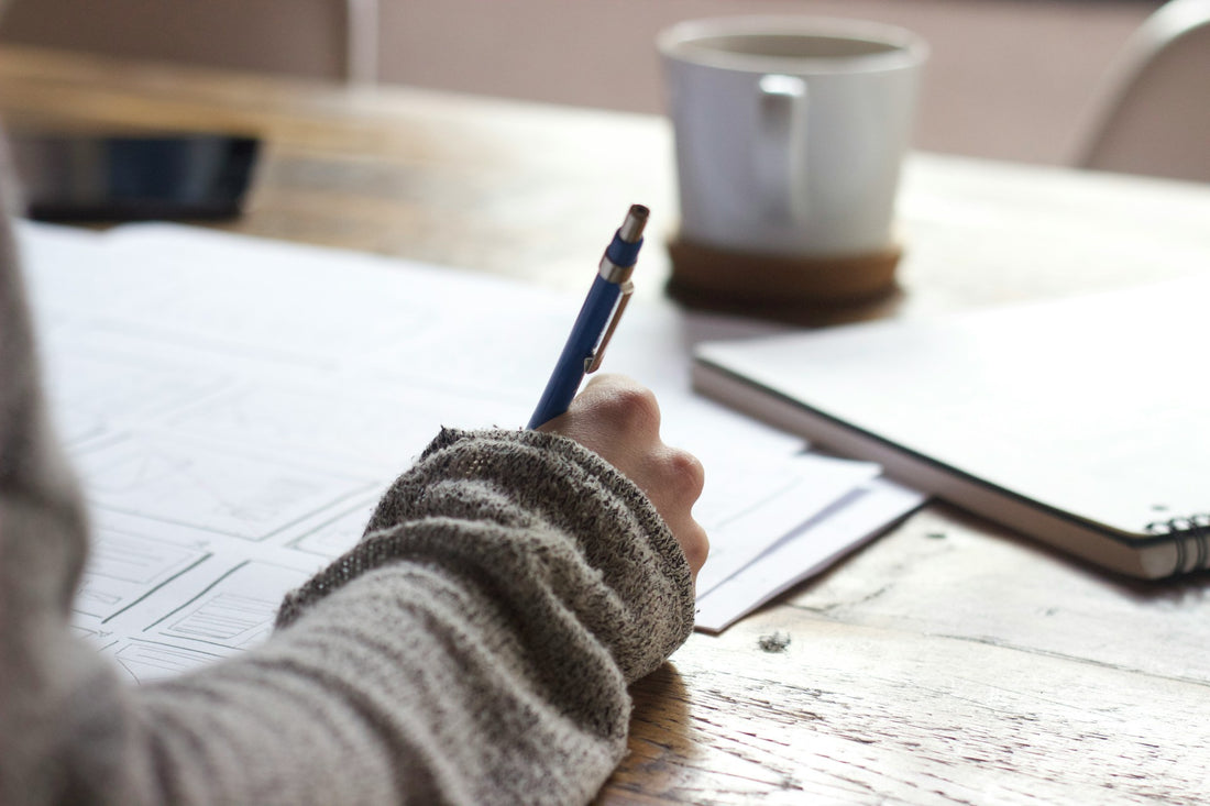 Woman Writing in Notebook Photo by Unseen Studio on Unsplash